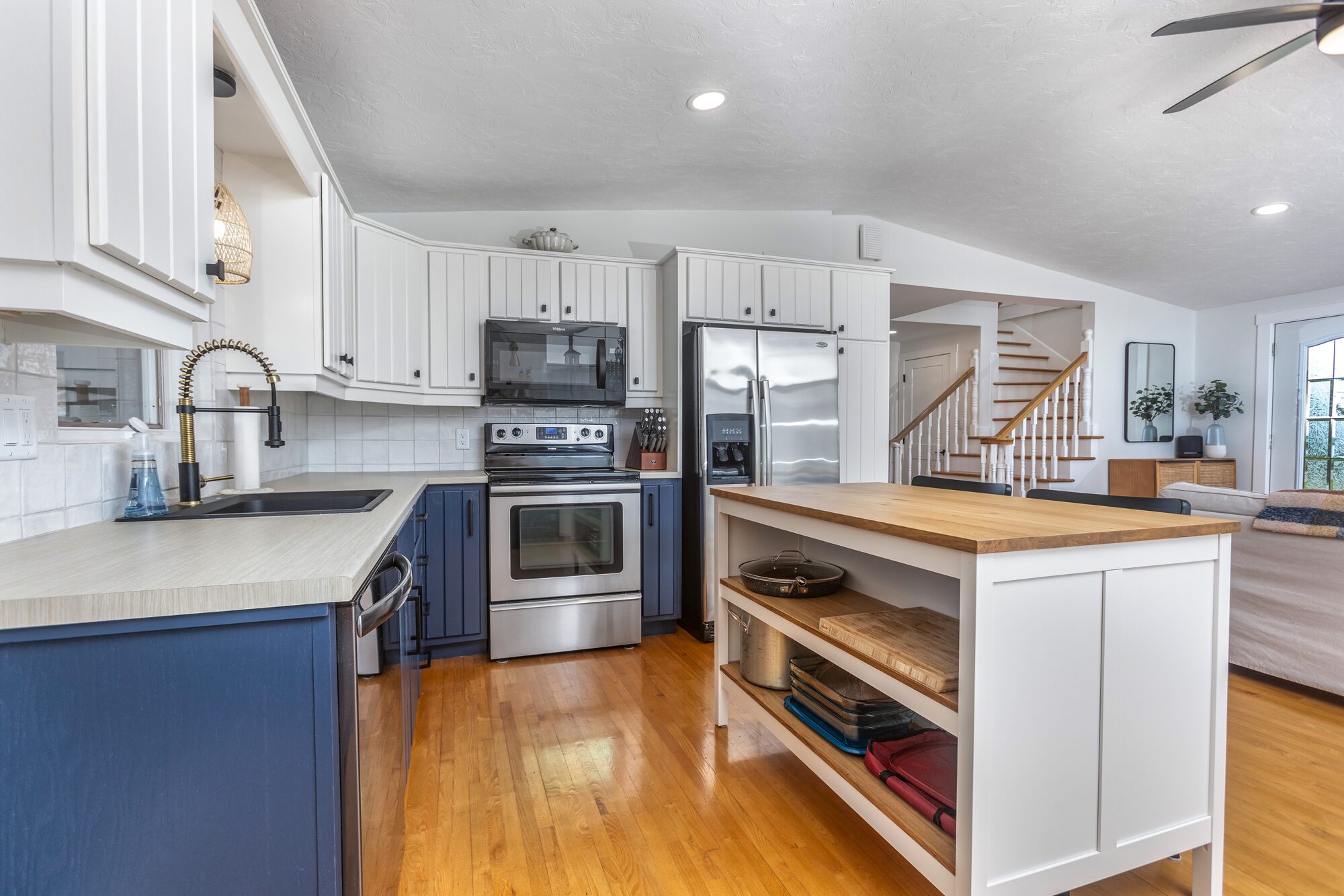 The kitchen looking through to the wraparound staircase and front entry.